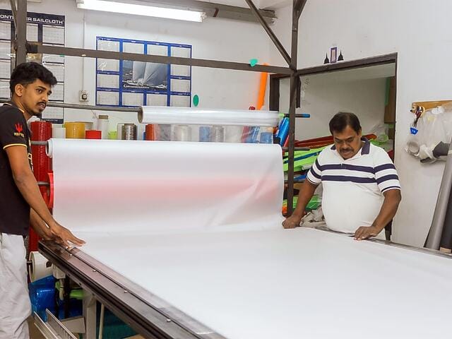 Rolling out sail material in the stores at the Ezzy factory